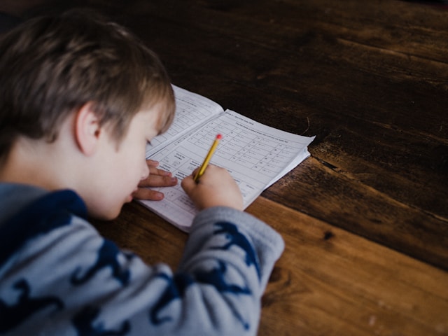 Boy writing in classroom